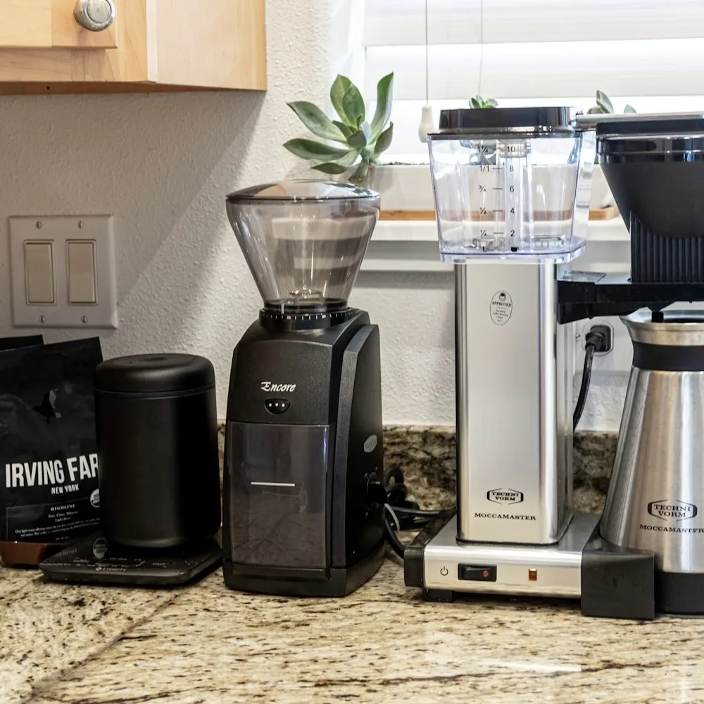 Cafetière électrique et moulin à café sur un plan de travail