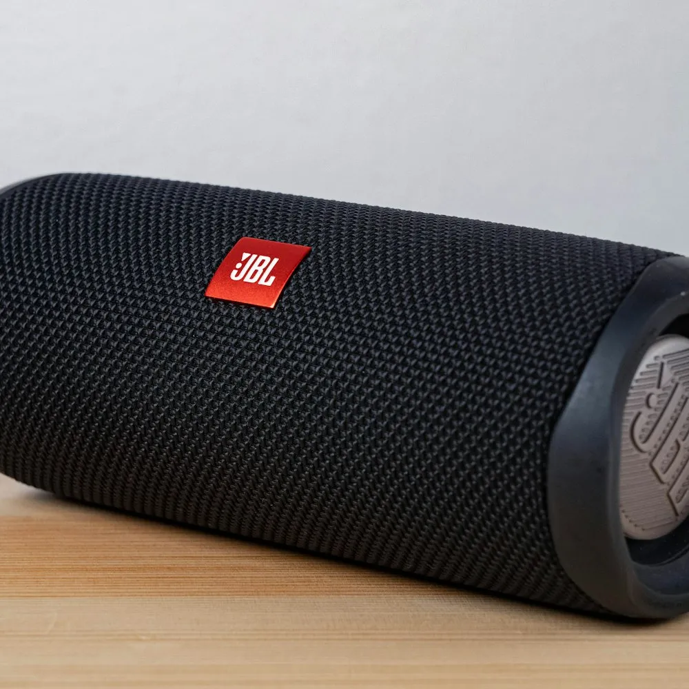 Enceinte portable JBL noire posée sur une table en bois