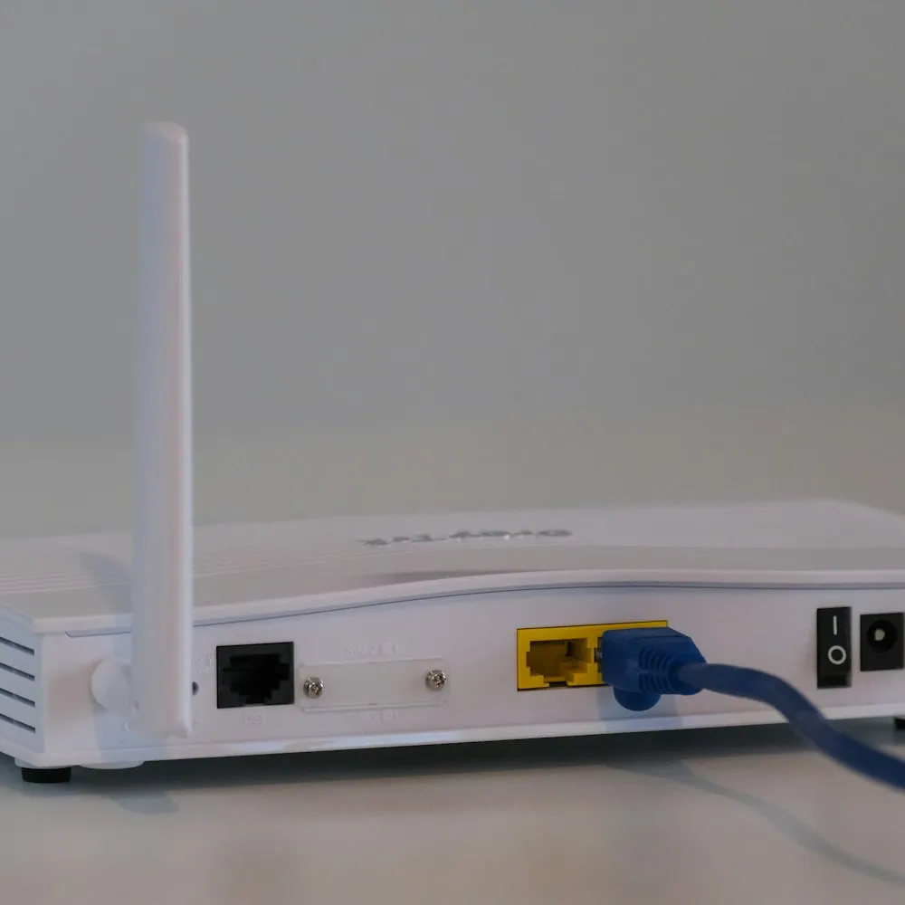 Routeur Wi-Fi blanc posé sur une table blanche